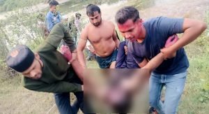 शव को नदी से बाहर निकालते स्थानीय लोग।